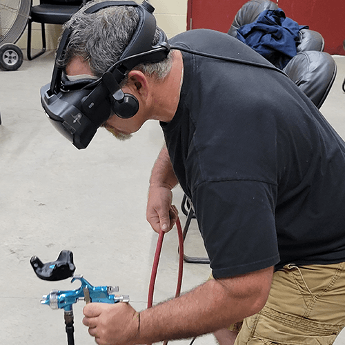 a man with virtual reality goggles and vr paint gun uses the VirtualPaint painter training program
