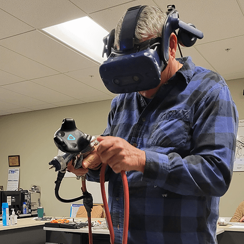 a man wearing virtual reality mask and holding a vr paint gunlooks down