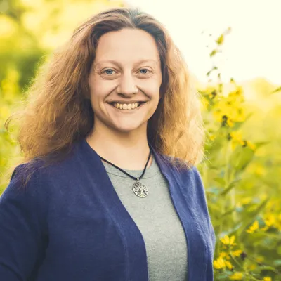 Anastasia Bender standing before field of yellow flowers