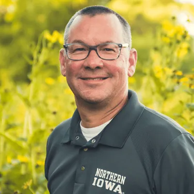 Link, Dan Nickey standing before field of yellow flowers, profile page