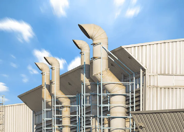 Ventilation shafts outside local business against blue sky.